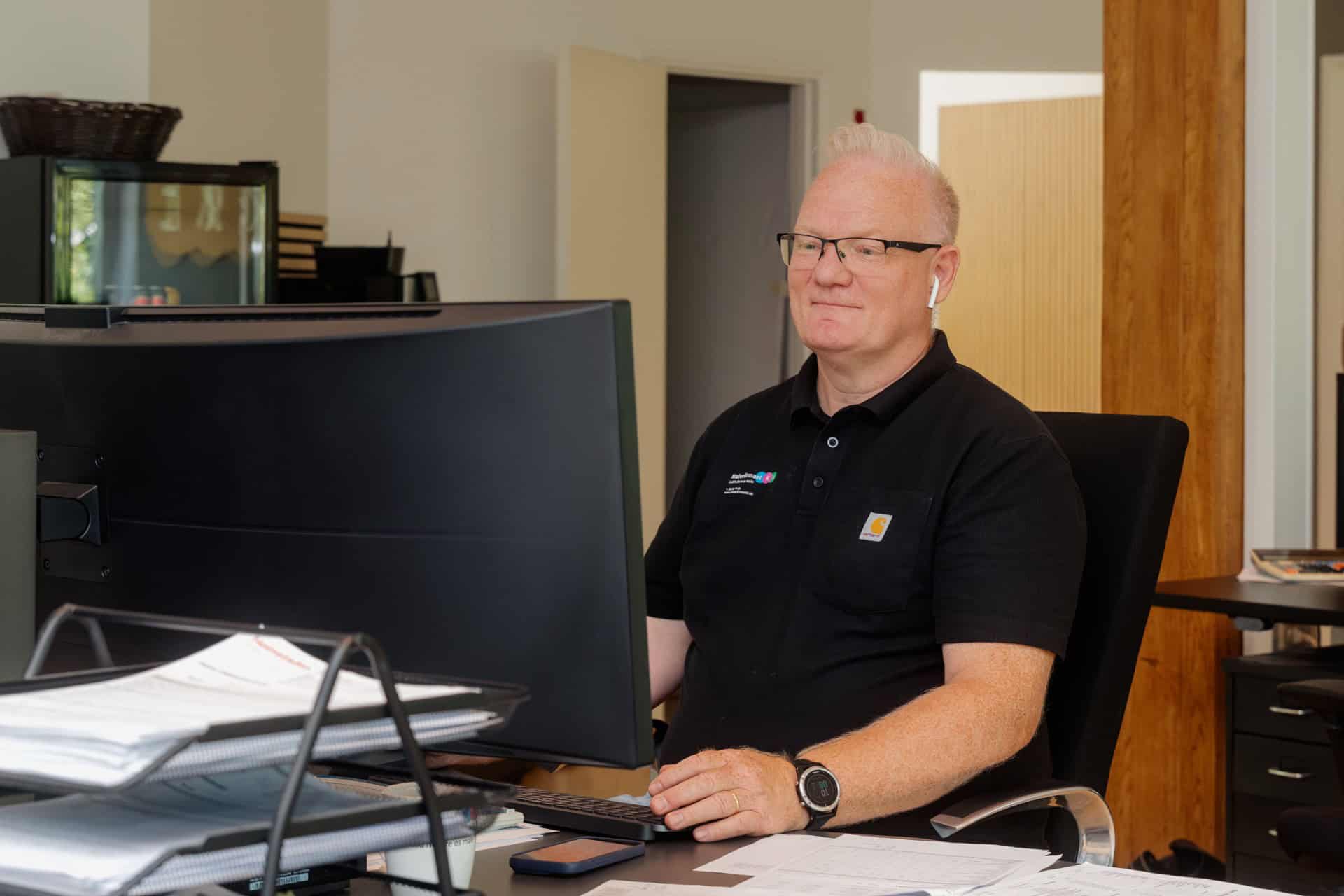Medarbejder fra Malerfirmaet KL sidder foran computer